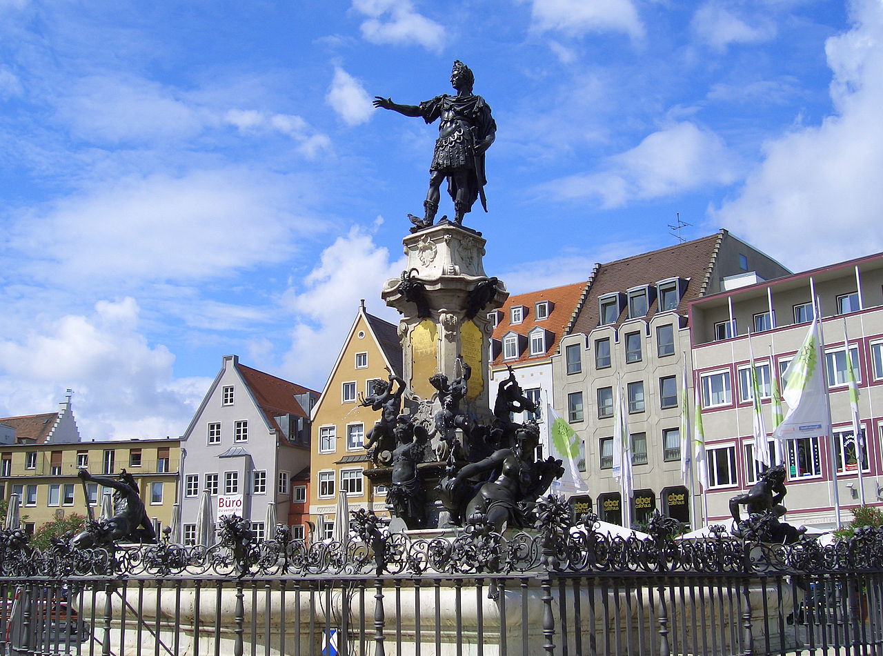 Augsburg ist eine Stadt mit gepflasterten Straßen, Kirchen und hohen Türmen